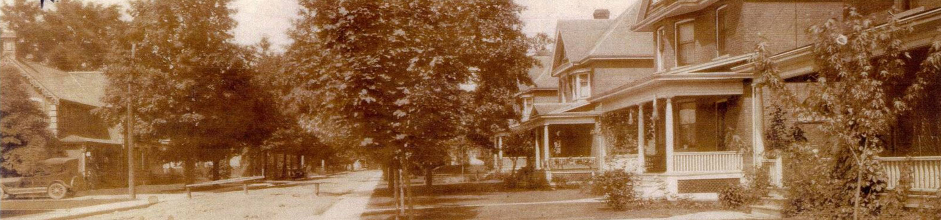 sepia-toned old photo of a residential street in the early 1900s.